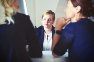 Donna che affronta un colloquio di lavoro con due selezionatrici Foto di Tim Gouw su Unsplash