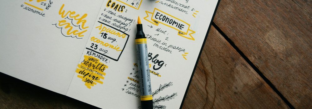 Libro planner con pennarello giallo che evidenzia obiettivi e to do list. Foto di Estée Janssens su Unsplash